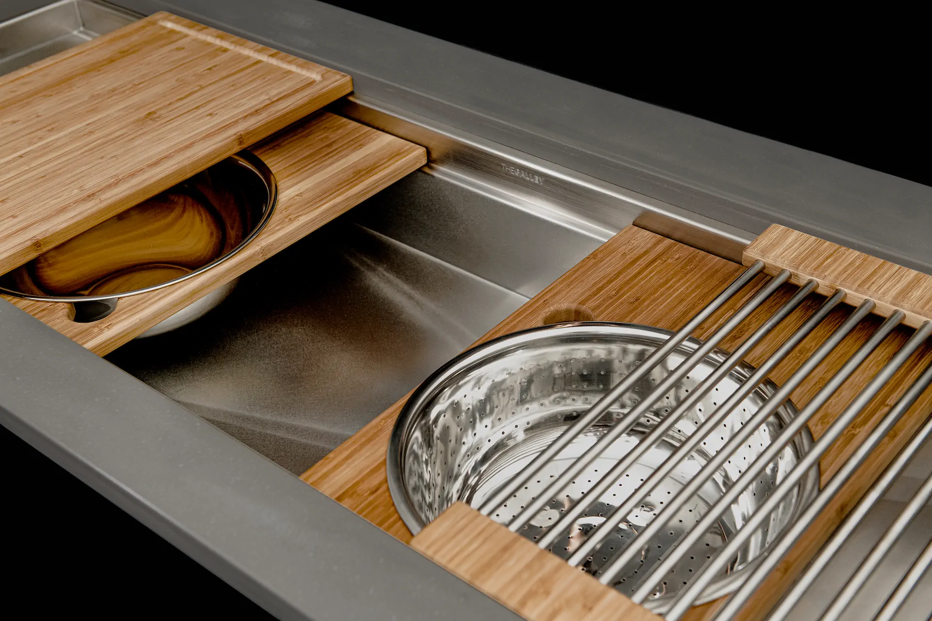 Close detail of The Galley Workstation basin, grates, drain, and accessory ledges