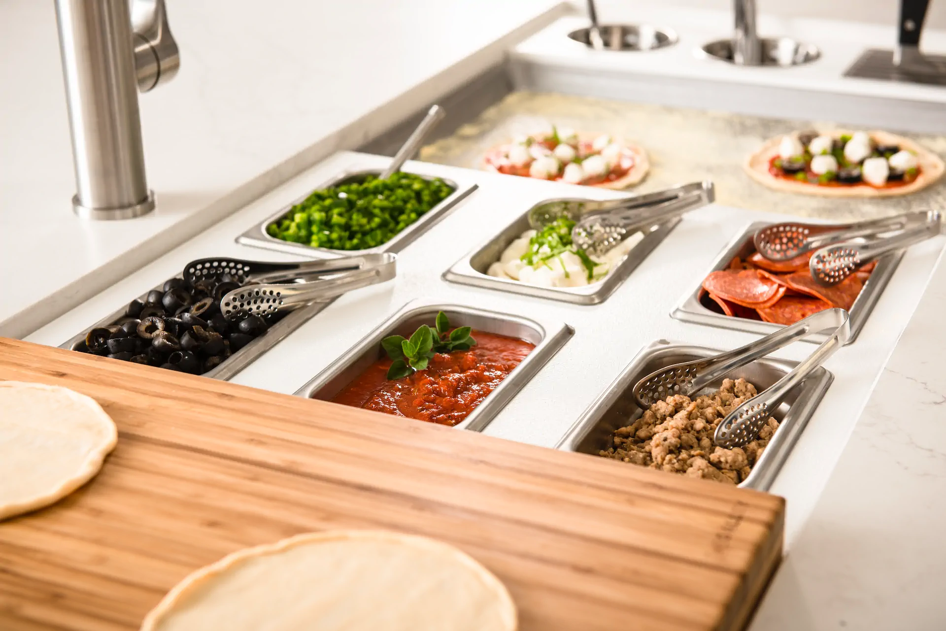 The Galley Culinary Kit tools arranged over a multi-tier workstation basin